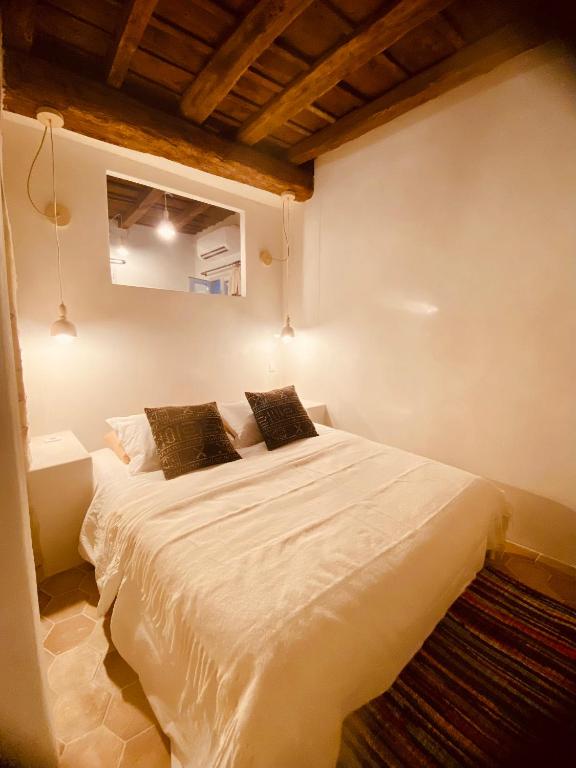 una camera da letto con un grande letto bianco con due cuscini di Citabella Bastia a Bastia
