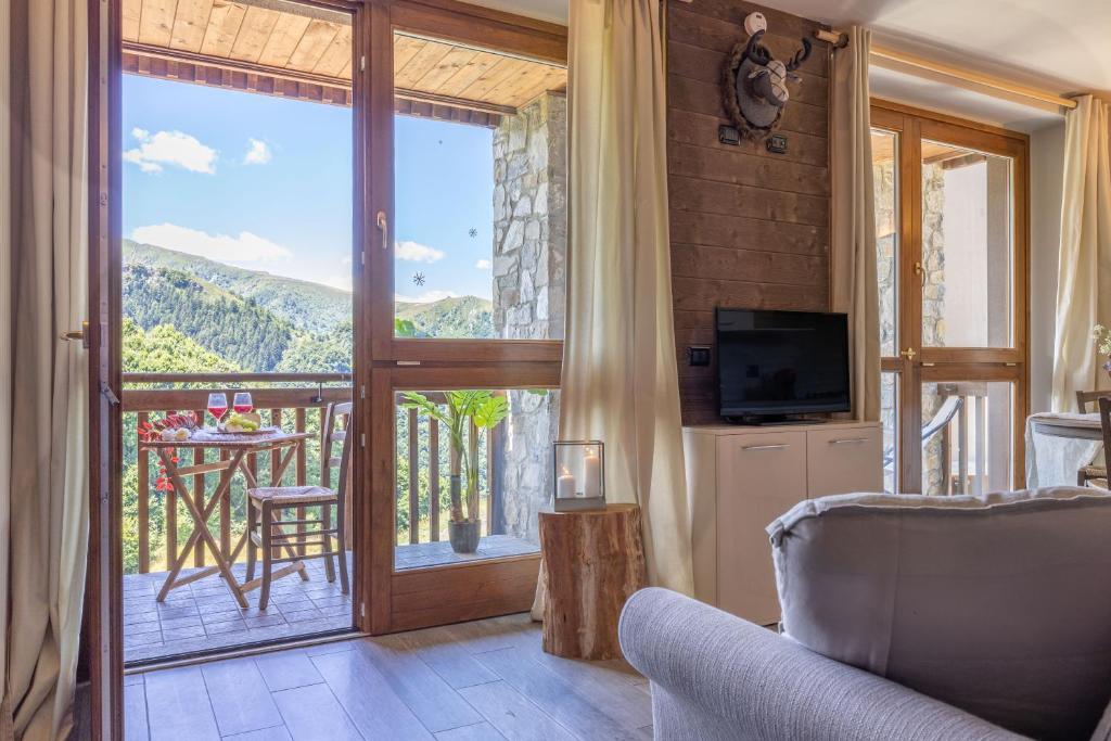 a living room with a sliding glass door to a balcony at Prato Nevoso - Alben Ski Apartment - GrandMaison in Prato Nevoso
