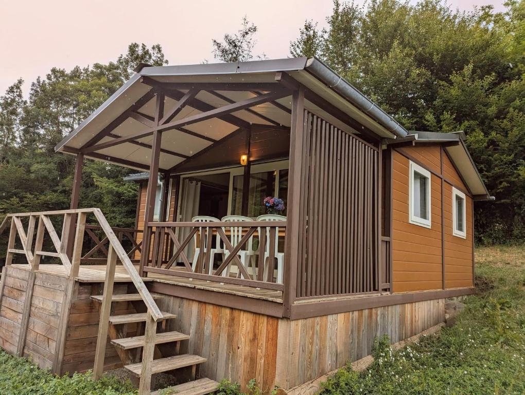 une cabane avec une grande terrasse avec un escalier dans la cour dans l'établissement Le Chalet de la Source, à Saint-Sylvain