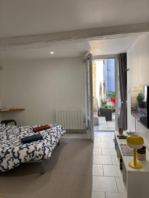 une chambre avec un lit et une porte coulissante en verre dans l'établissement Studio 83, à Caen