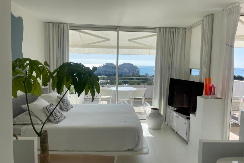 une chambre blanche avec un grand lit et une télévision dans l'établissement BRAND NEW 2 BR in Villeneuve-Loubet sea view terrasse & parking - BENAKEY, à Villeneuve-Loubet