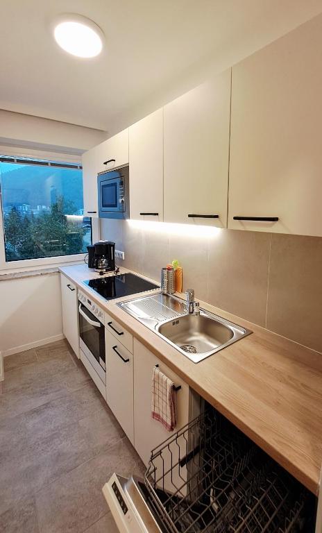 a kitchen with white cabinets and a sink and a window at Apartment Gastein 2 in Bad Gastein