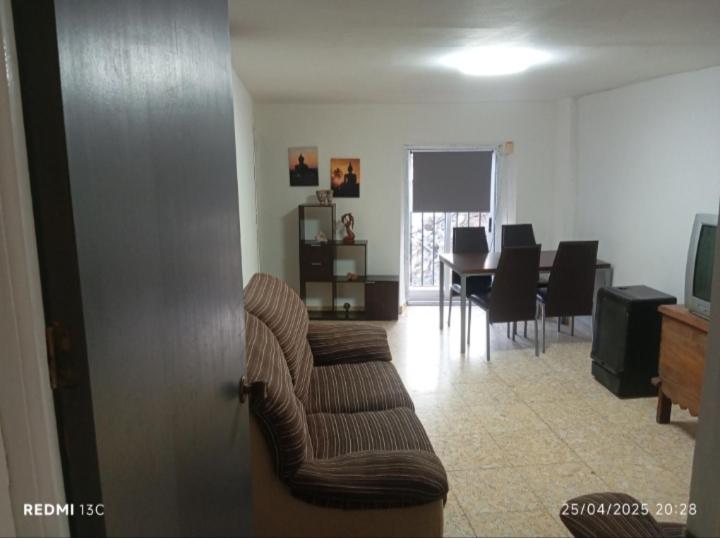 ein Wohnzimmer mit einer Couch und einem Tisch mit Stühlen in der Unterkunft La posada del Mozarabe in Alquife