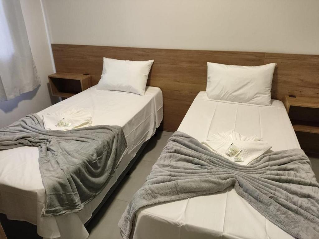 two beds sitting next to each other in a room at Mahle Hotel Jataí in Jataí