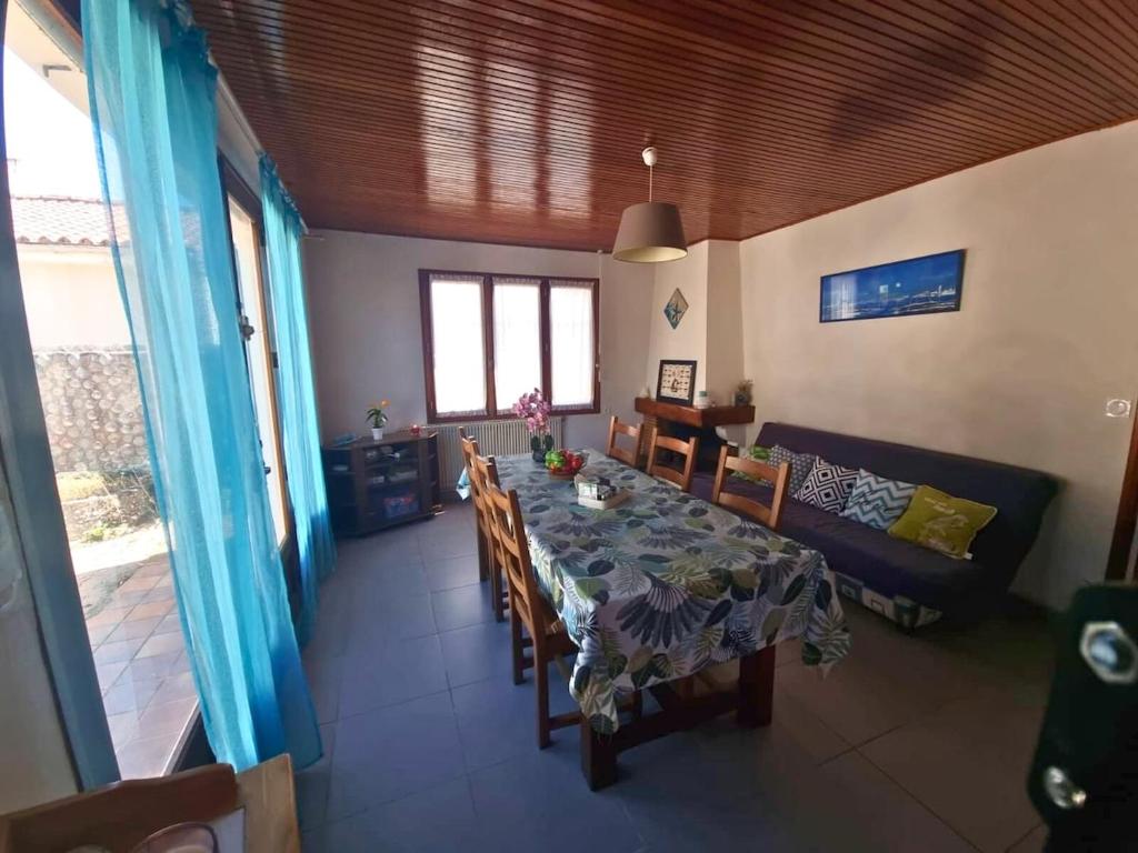 Un comedor con una mesa y un sofá. en maison mer et soleil, en La Plaine-sur-Mer