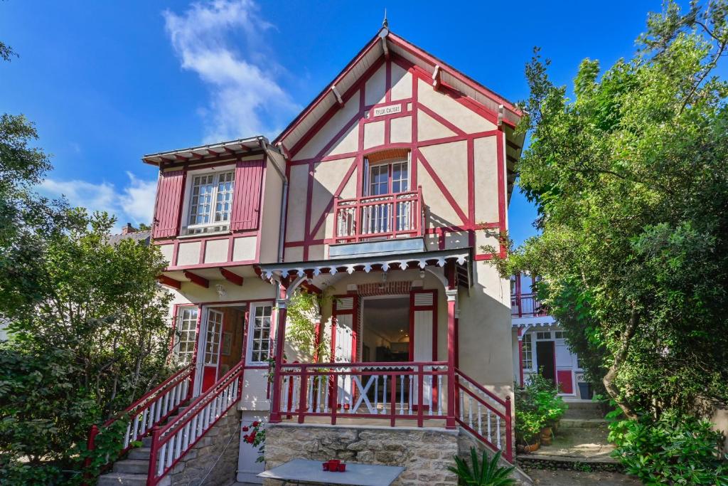a red and white house with a balcony at Petit Colibri - Proche de la plage in La Baule
