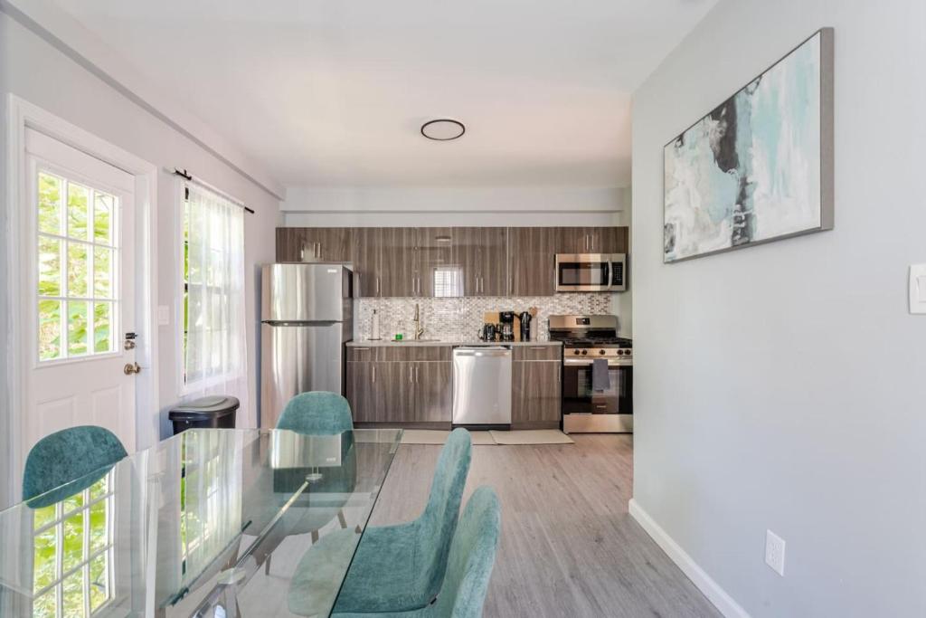 a kitchen with a glass table and green chairs at Modern House in Black Rock in Bridgeport
