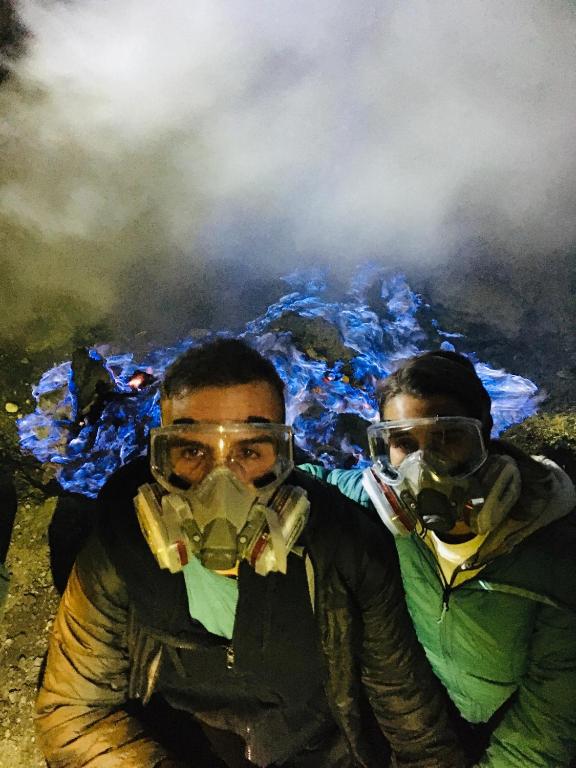two men wearing gas masks in front of a pile of smoke at Nio Homestay and Tour in Licin