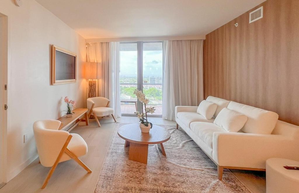 a living room with a white couch and a table at 1br BeachWalk Ocean View in Hallandale Beach