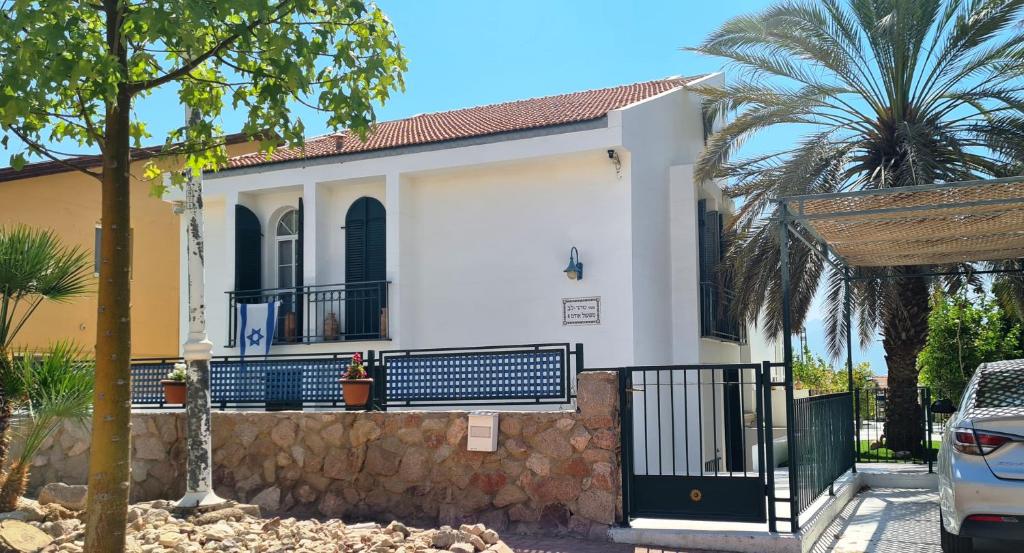 a white house with a gate and a fence at Like home at the Tehar-Lev family in Eilat