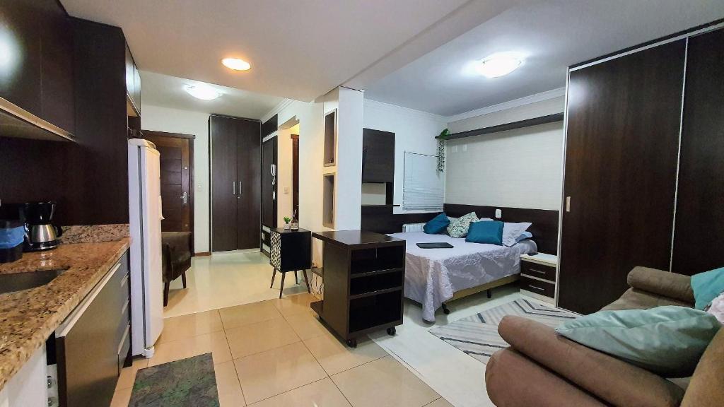 a hotel room with a bed and a kitchen and a living room at Baviera Studio Canela in Canela