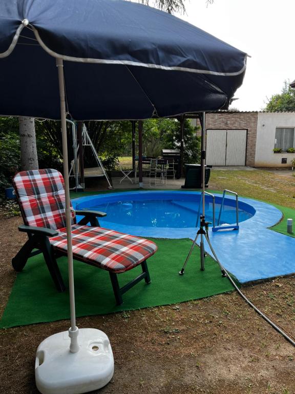 a chair and an umbrella next to a pool at Pelso d'Oro apartmanház in Balatonföldvár