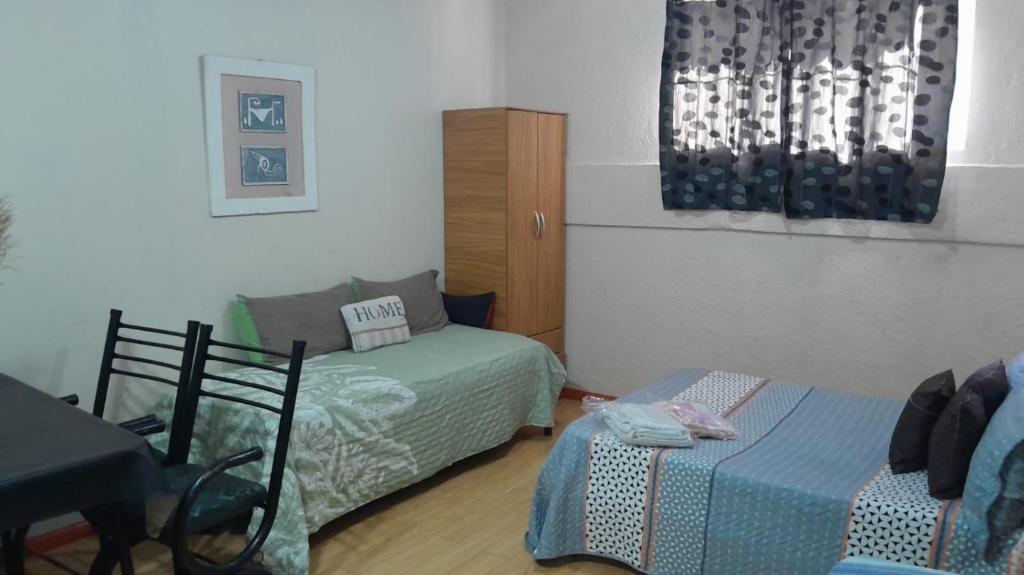 ein Zimmer mit einem Bett, einer Couch und einem Tisch in der Unterkunft Departamentos Avenida San Martin in Mendoza