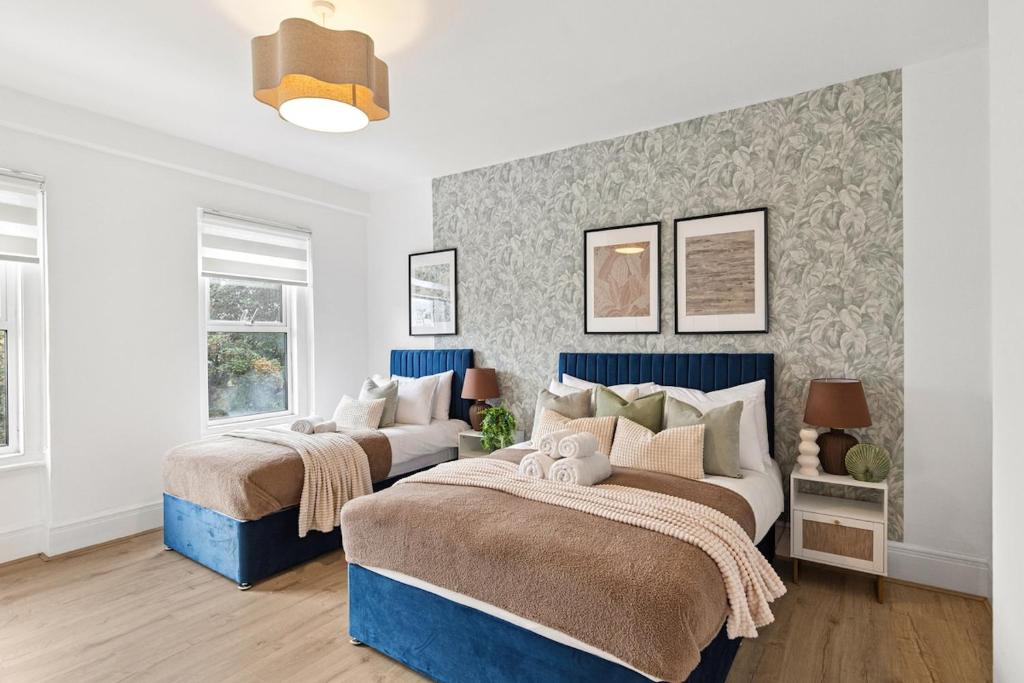 two beds in a bedroom with blue and white at Pimlico gem Central London next the London Eye in London