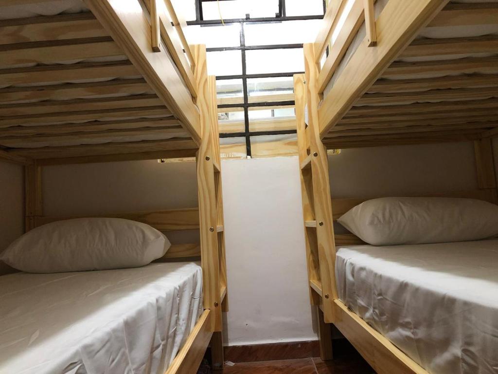 two bunk beds in a room with wooden ceilings at Apartamentos contiguos cerca a Parque de Bello Antioquia in Bello