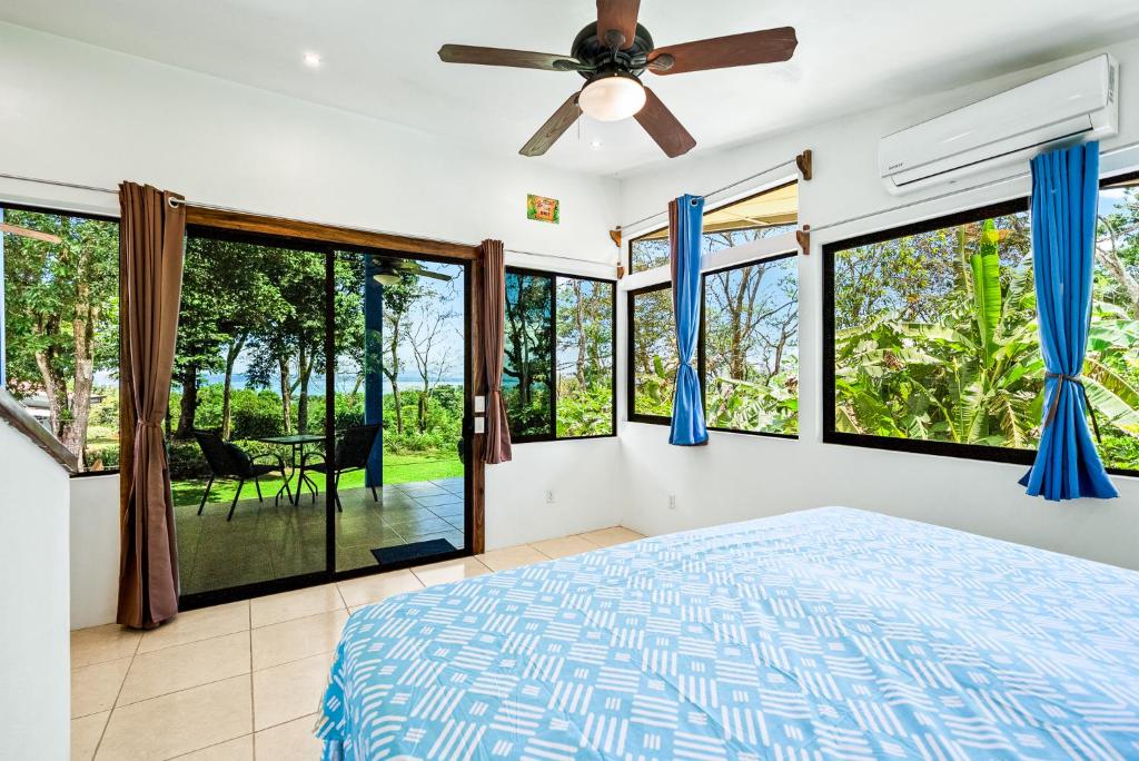 a bedroom with a bed and large windows at Ocean View Modern Dream House 1 in Pavones