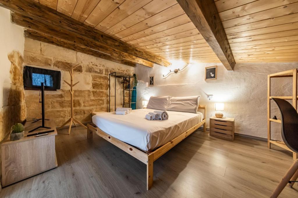 a bedroom with a bed in a room with wooden ceilings at SASSARI-CENTRO Elegante Appartamento con WiFi e Netflix in Sassari
