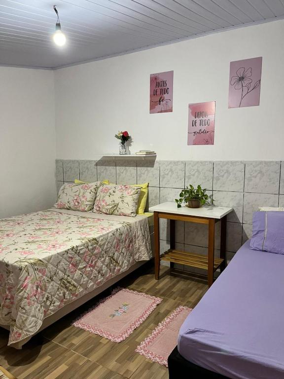 a bedroom with two beds and a table with two tables at Suíte Freitas Piri in Pirenópolis
