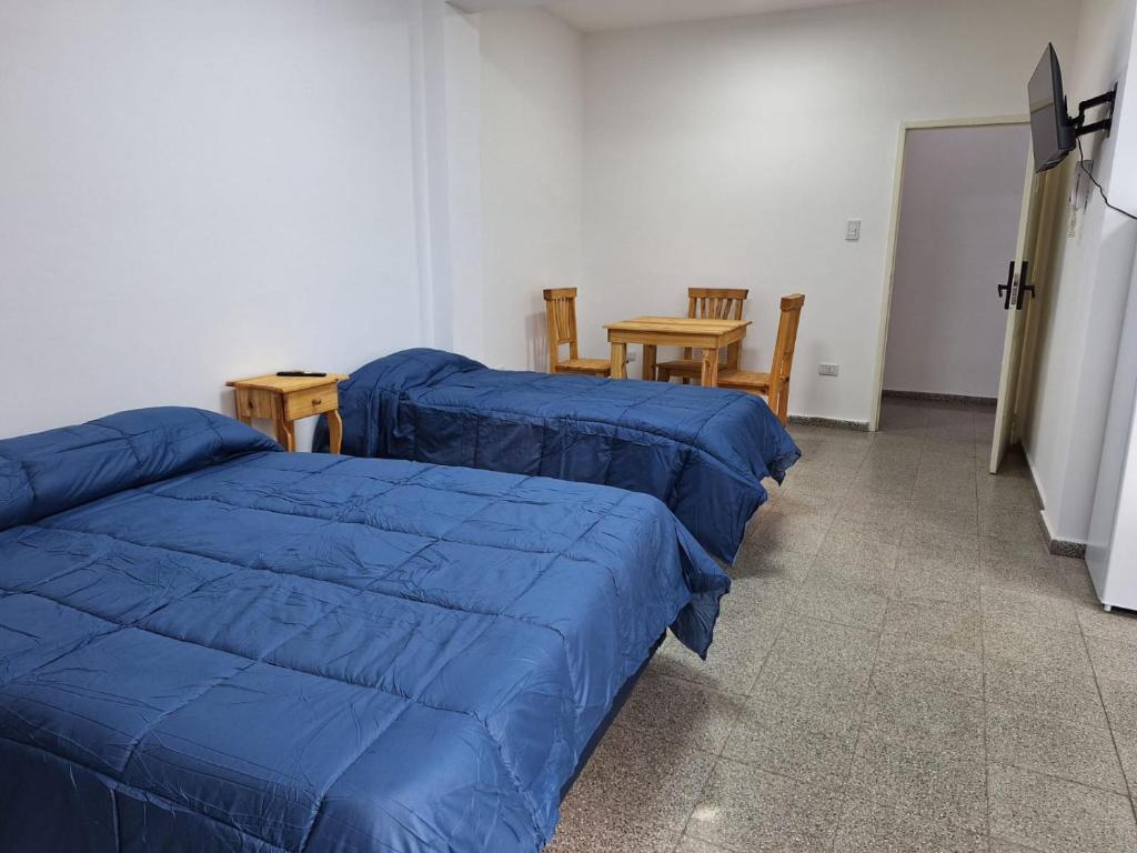 una camera con tre letti e un tavolo con sedie di Santa Rita Dpto 9 a San Fernando del Valle de Catamarca