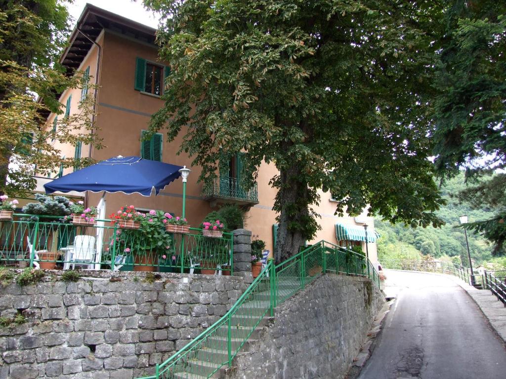 una casa con un ombrello e un muro di Hotel Villa Patrizia a Cutigliano