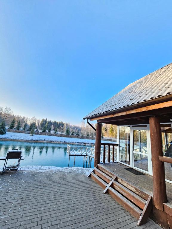 einen Pavillon mit einer Bank neben einem See in der Unterkunft Sodyba Prie Maluno in Salakas