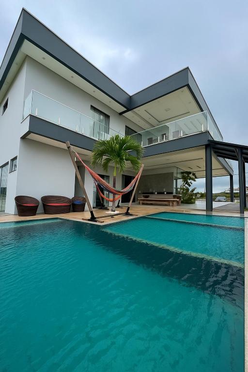 a house with a swimming pool next to a house at Casa COP 30 alto padrão in Santa Isabel do Pará