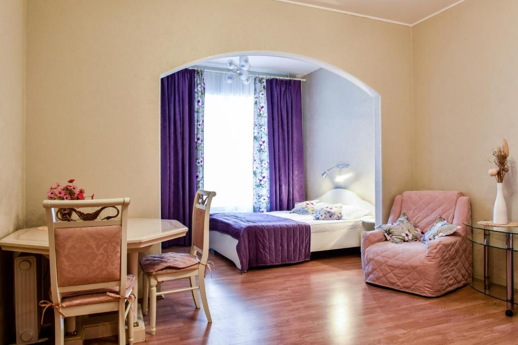 a bedroom with a bed and a chair and a window at Nevsky Row Hotel - Nevsky 100 in Saint Petersburg