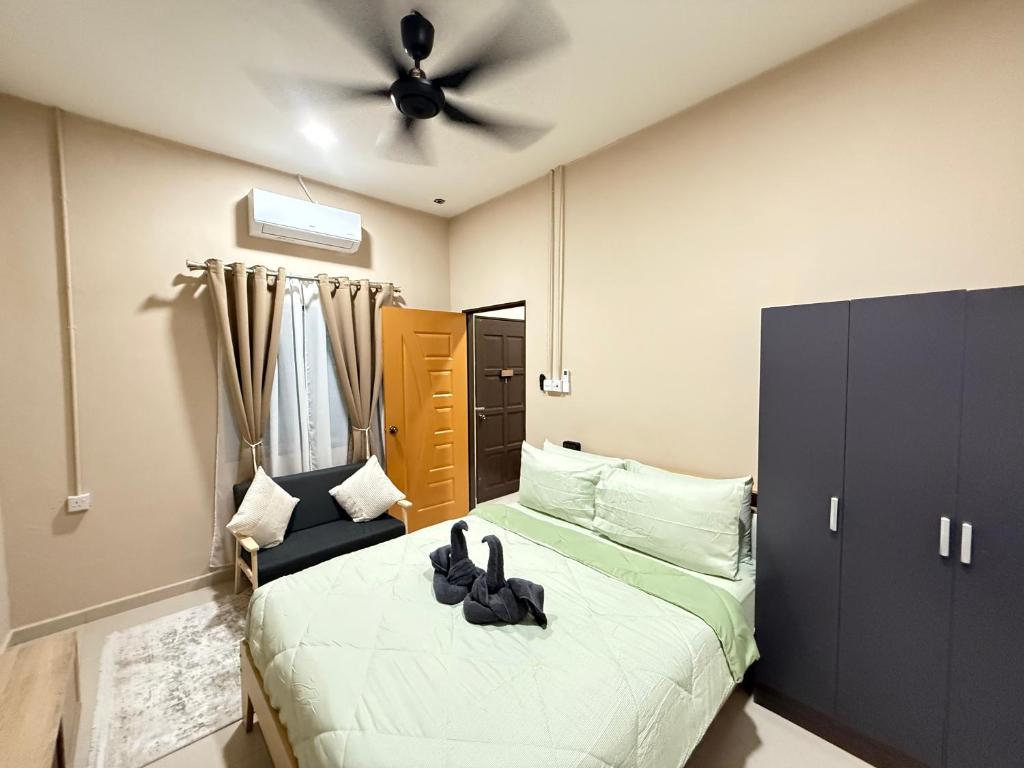 a bedroom with a bed and a ceiling fan at Rumah No 5 in Taiping