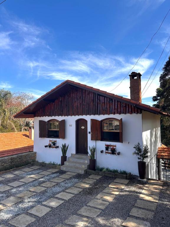 a white house with a brown roof at Villaggio Harmonia Monte Verde in Camanducaia
