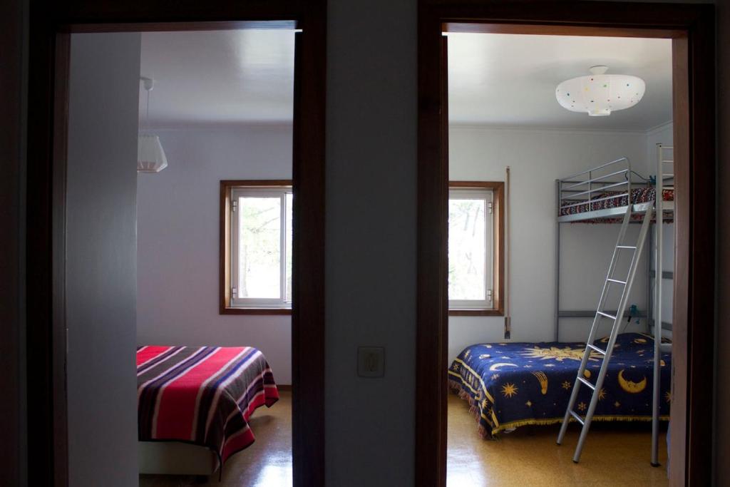 a bedroom with a bunk bed and a ladder at Our sweet flat by the beach in Viana do Castelo