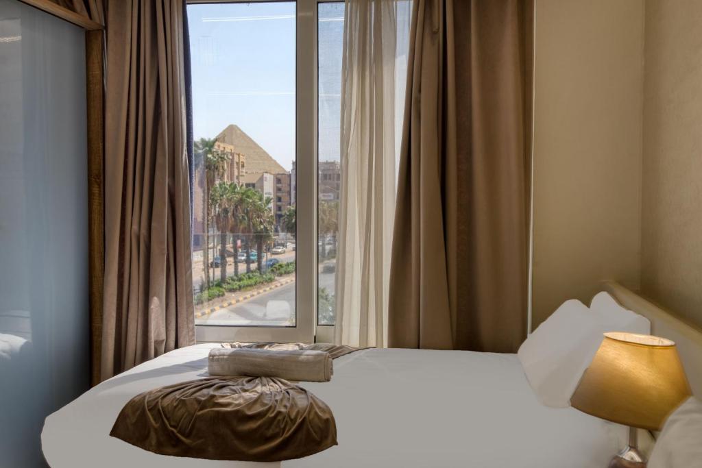 a hotel room with a bed and a window at New dust pyramids hotel in Cairo