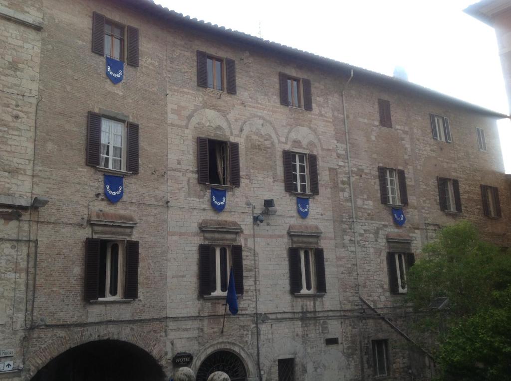a large brick building with windows and blue decorations on it at Albergo Anna in Perugia
