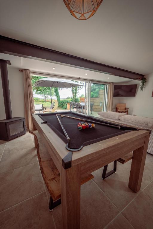 - un billard au milieu d'une pièce dans l'établissement Maison vu Lac en première ligne du lac de Lacanau avec terrain de tennis privatif, à Lacanau