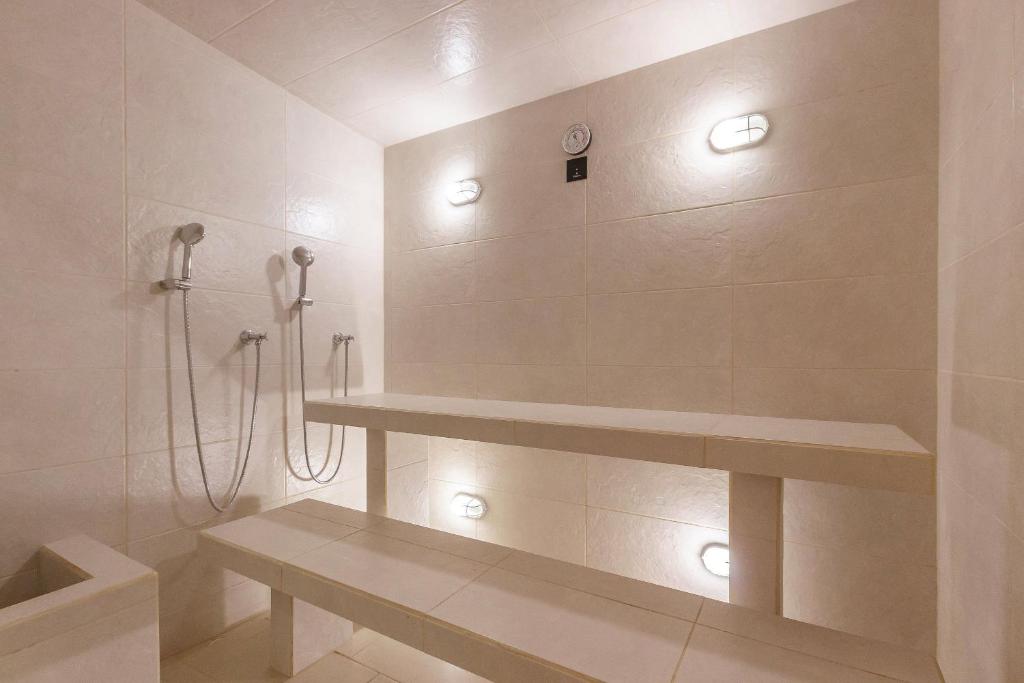 a bathroom with a shower with lights on the wall at U-GO Eira: Lujo y Serenidad Frente al Mar en Santa Marta in El Prado