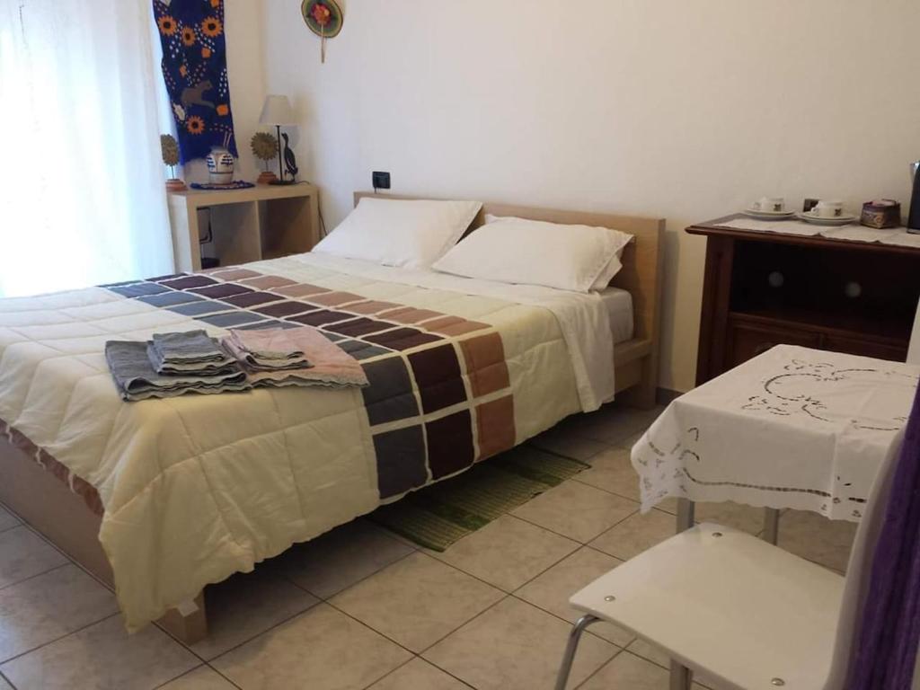 a bedroom with a bed and a table and a chair at Casa Nicoletta Apartment in Ravenna