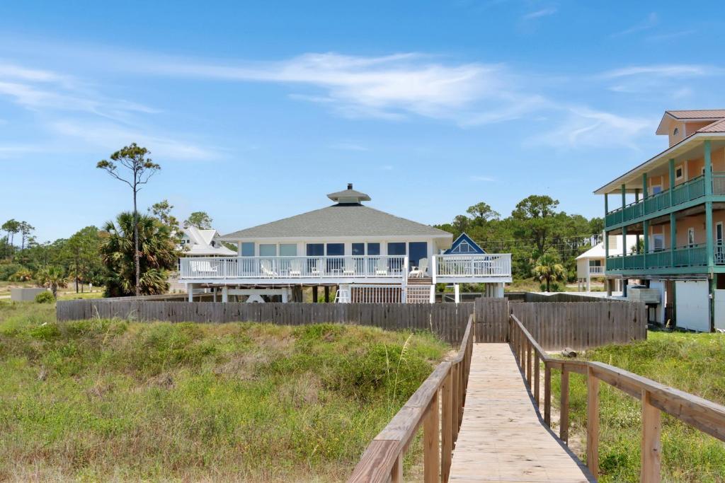 una casa sulla spiaggia con una passerella di legno di Breezeway By Pristine Properties Vacation Rentals a Indian Pass