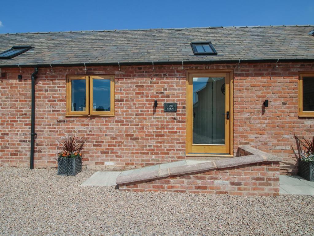a brick house with a door and a staircase at Oak Barn in Shrewsbury