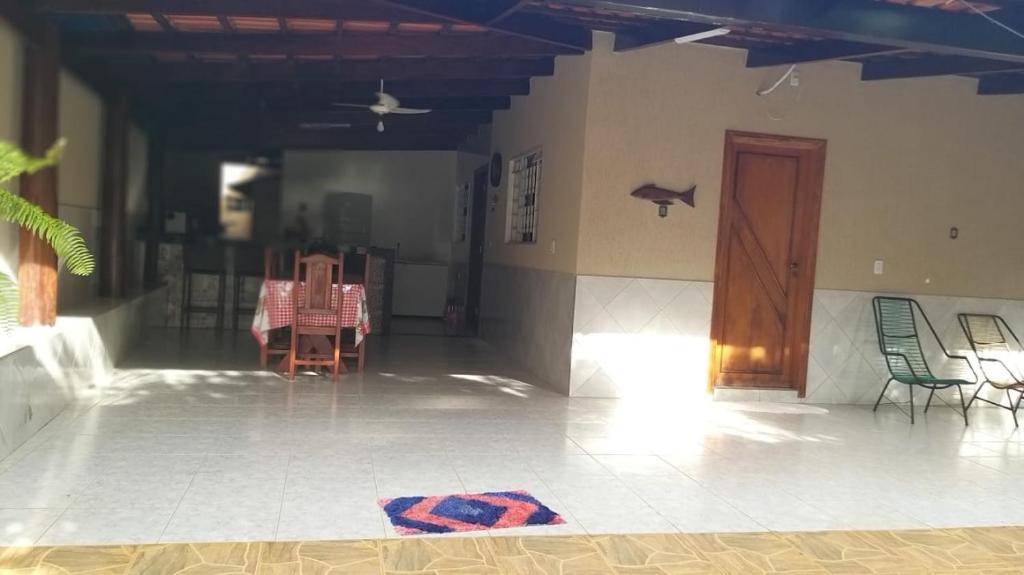 a room with chairs and a table and a door at Casa de temporada em Aruanã in Aruanã