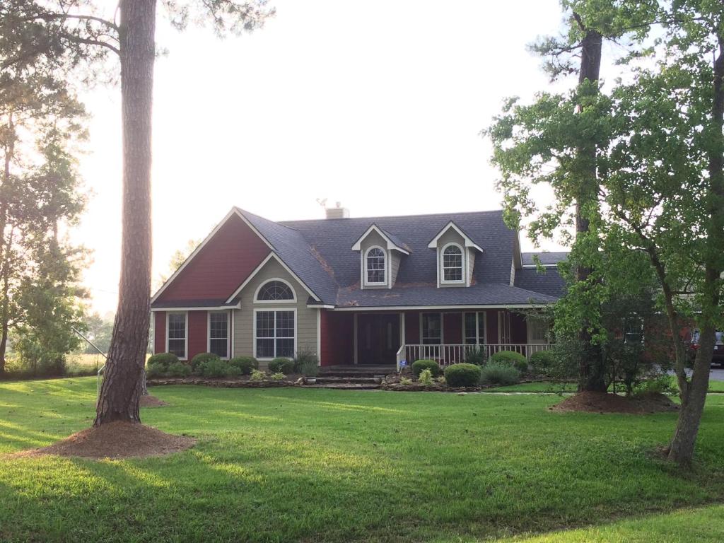 a house with a green yard with trees at Maple Creek Bed&Breakfast in Tomball