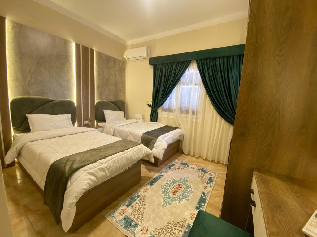 a hotel room with two beds and a window at Global pyramids boutique in Cairo