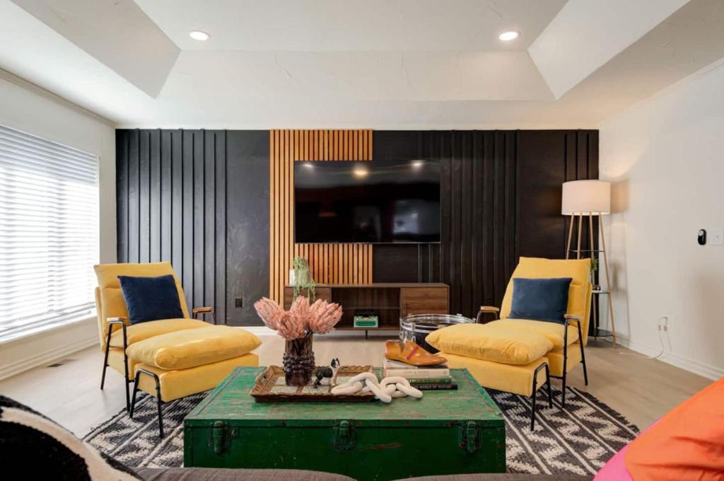Una sala de estar con sillas amarillas y una mesa. en Ultimate Game Night Getaway Hot Tub, Arcade & Fun, en Oklahoma City