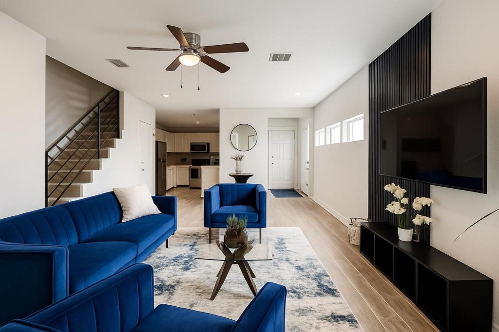a living room with blue couches and a tv at Three Bedroom ClubHaus in Houston
