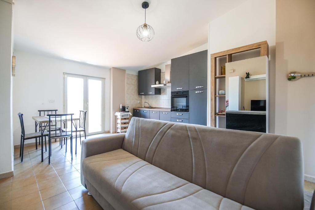 a living room with a couch and a kitchen at My Toy Holiday Pompei in Pompei
