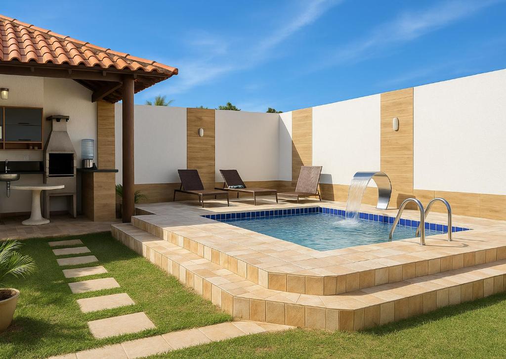a backyard with a swimming pool and a house at Casa em Jauá in Camaçari