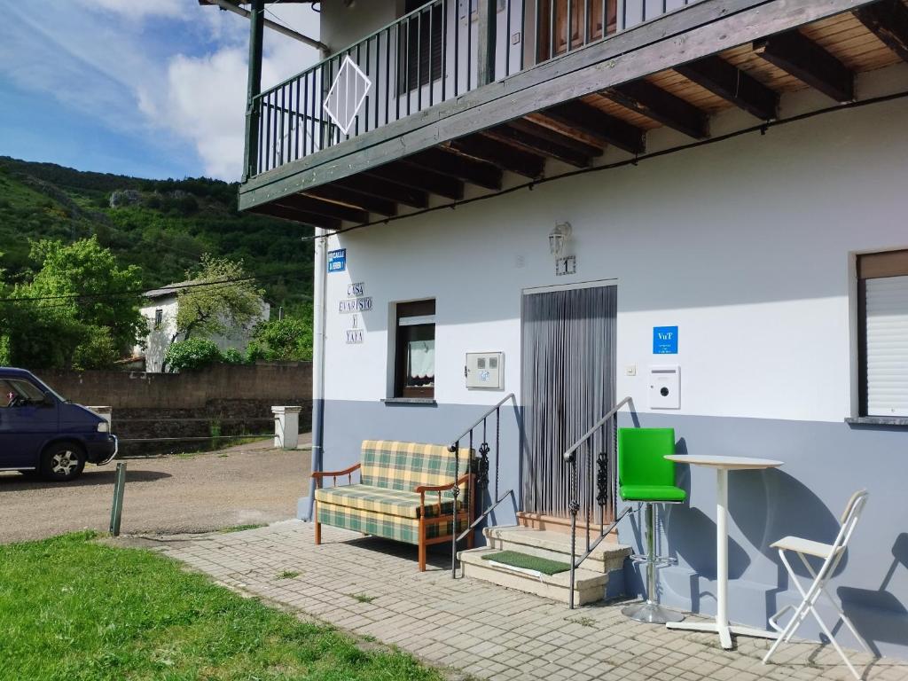 a house with a bench and a table on the side at La Guaja vivienda de uso turístico in Olleros de Sabero
