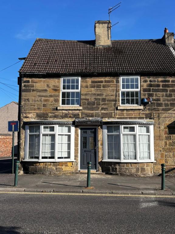 a brick house with white windows and a door at Guisborough 3-Bed, with parking, Walk to Pubs, Shops & Trails in Guisborough