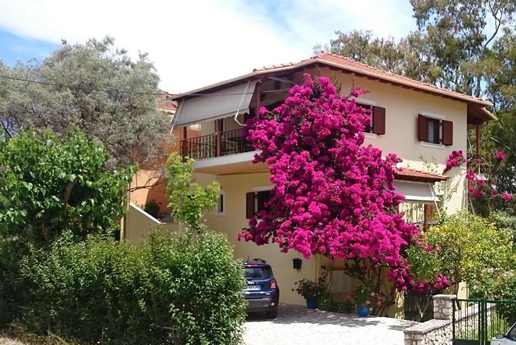 dom z różowymi kwiatami na boku w obiekcie Grammatoula w mieście Nikiana
