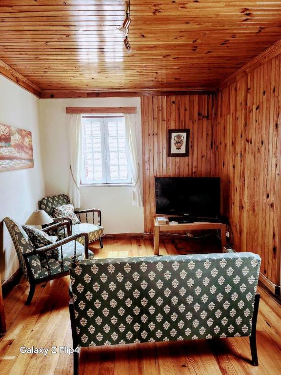 un soggiorno con divano e televisore di Casa Vidas de Loriga a Loriga
