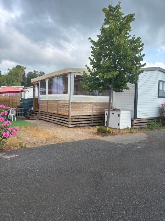 a house with a tree in front of it at Mobilhome Camping piscine Hyères Plage in Hyères