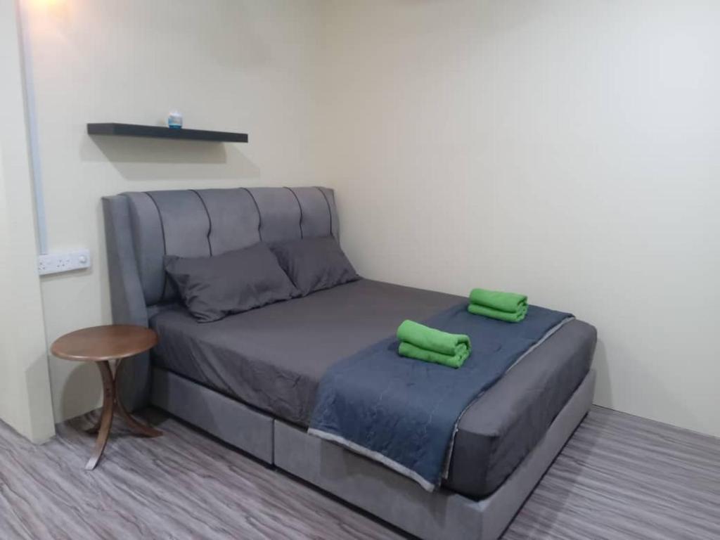 a bed with two green pillows on it in a room at OceanBoys Chalet Coral Bay in Kampong Pasir Panjang